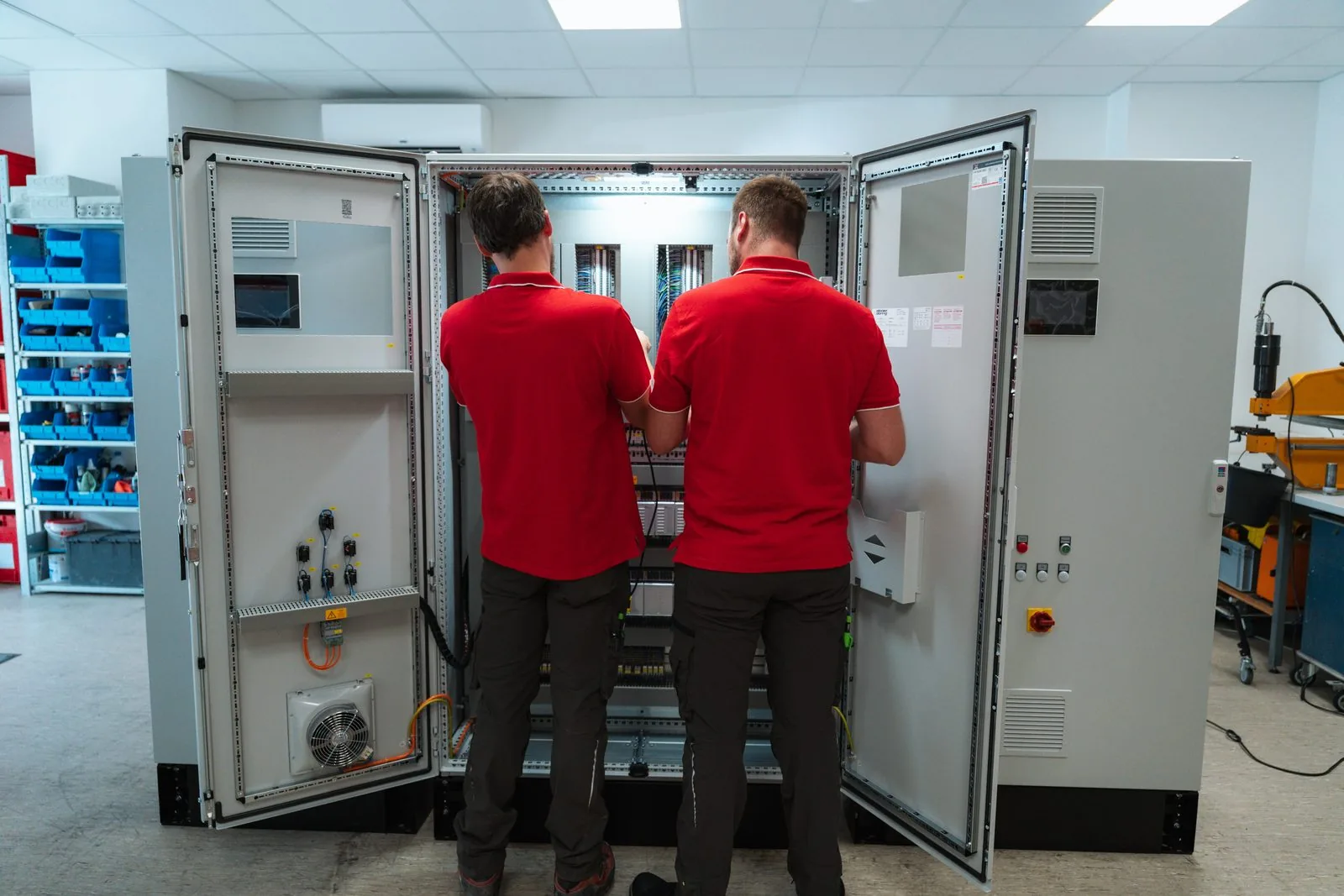 Zwei Elektroniker verdrahten einen Schaltschrank in der Werkstatt